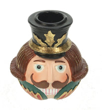 Lade das Bild in den Galerie-Viewer, Kerzenhalter für eine Stabkerze in Form eines Nussknacker-Kopfs mit schwarzem Hut, grünem Kragen und braunem Haar und einem braunen Shnurrbart.
