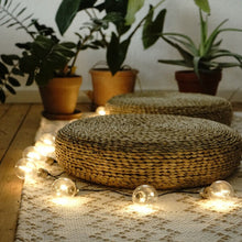 Lade das Bild in den Galerie-Viewer, Bodenkissen aus geflochtenem Rattan auf dem Boden dekoriert mit Lichterkette.
