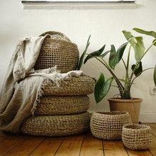 Lade das Bild in den Galerie-Viewer, Boho Interior mit geflochtenen, runden Sitzkissen aus Stroh.