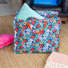 Lade das Bild in den Galerie-Viewer, XXL Aufbewahrungstasche von Rex London mit Marienkäfer-Muster. IN der Tasche ist ein blaues Kissen, die Tasche steht vor einem Ledersessel auf einem Strohteppich, auf dem ein Kissen und eine Decke liegen.