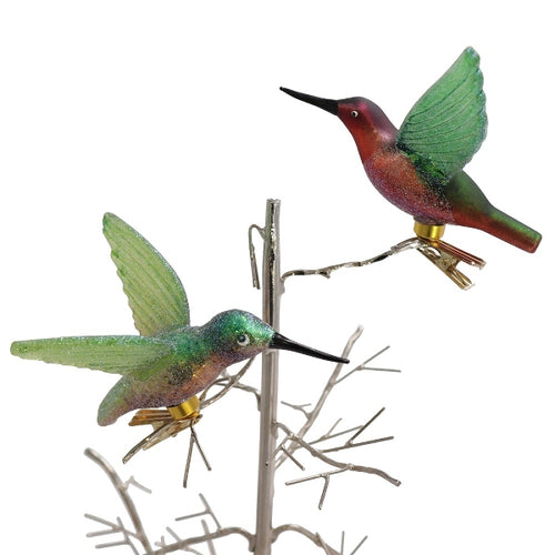 2 Kolibris aus Glas, die mit einem Clip auf Zweigen befestigt sind.