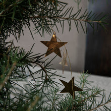 Lade das Bild in den Galerie-Viewer, Detailaunahme der goldenen Metallsterne der House Doctor Girlande "Star" an einem Tannenbaum.