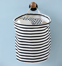 Lade das Bild in den Galerie-Viewer, Der Stoffkorb "Stripes" von House Doctor hat ein schwarzes Streifenmuster auf einem naturfarbenen, leinenartigen Stoff. Mit praktischem Henkel zum Aufhängen.