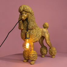 Lade das Bild in den Galerie-Viewer, Lampe in Form eines goldenen Pudels von werner Voß. Der Hund hält ein Kabel in der Schnauze an dem eine Fassung für eine Glühbirne hängt.