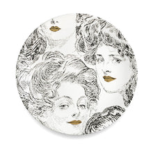 Lade das Bild in den Galerie-Viewer, Wandteller aus weißem Porzellan mit einem Motiv von Frauenköpfen. Die Gesichter der Frauen sind in schwarz aufgedruckt, die Lippen der Damen sind gold-farben. Moderne Design-Wanddeko im Stil von Fornasetti.