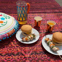 Lade das Bild in den Galerie-Viewer, Outdoor-Teppich aus gewebtem Kunststoff von Talking Tables, Modell "Boho Spice". Der Teppich ist rot-orange-pink-schwarz meliert mit blassem orientalischen Muster.