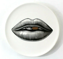 Lade das Bild in den Galerie-Viewer, Wandteller aus weißem Porzellan mit einem Lippen-Motiv. Der Mund ist in schwarz aufgedruckt, ein Zahn ist gold-farben. Moderne Design-Wanddeko im Stil von Fornasetti.