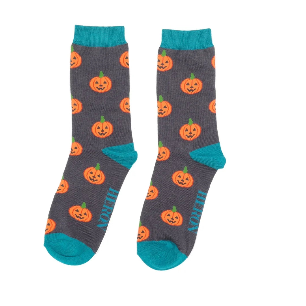 Herrensocken von Mr. Heron in dunkelgrau mit orangem Halloween-Kürbis-Muster und türkisem Bündchen.