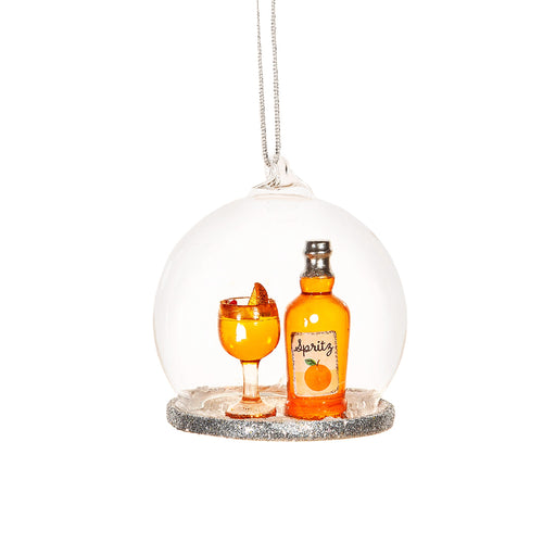 Weihnachtsanhänger mit einer Flasche Orange Spritz und einem gefüllten Glas unter einer Glaskuppel.