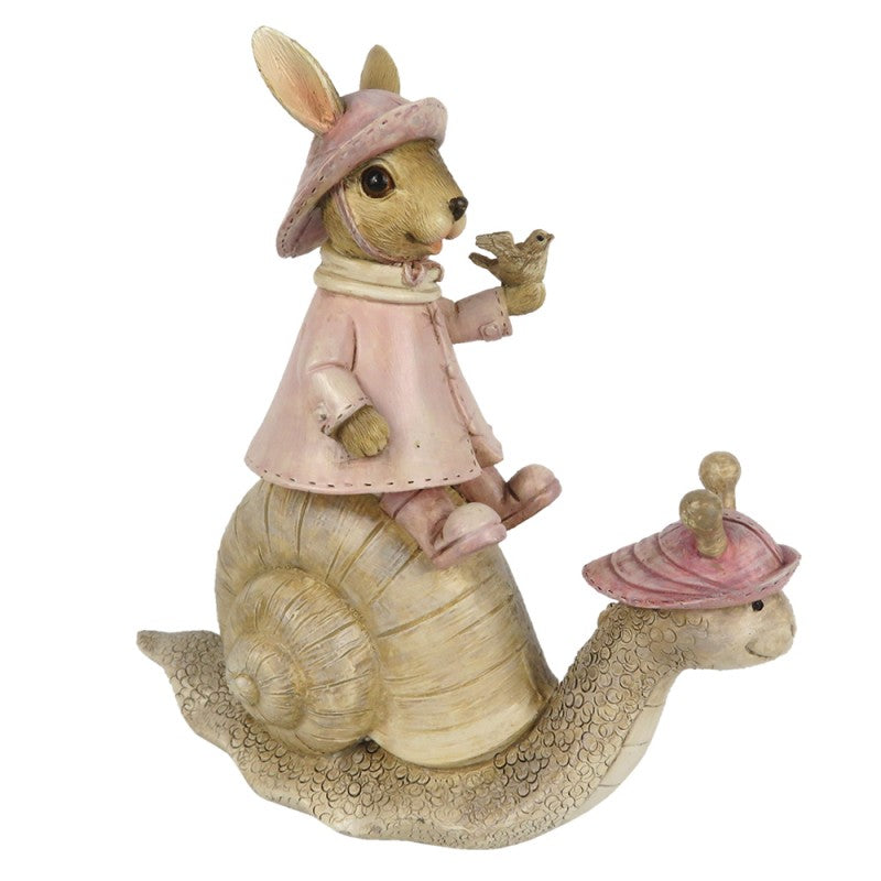 Deko-Figur für Ostern von Clayre und Eef. Ein kleiner Hase reitet auf einer Schnecke und trägt einen Vogel in der Hand. Osterhase und Schnecke tragen einen rosa Regenhut, das Häschen noch einen Regenmantel und Gummistiefel.