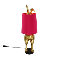 Lade das Bild in den Galerie-Viewer, Die Lampe Hiding Bunny von Werner Voss ist ein goldfarbener Hase, der sich hinter einem pinken Lampenschirm versteckt. Die Beine und Ohren des Osterhasen gucken hervor. Ideal als Stehlampe im Wohnzimmer oder Leuchte für Ostern und die Osterdeko.
