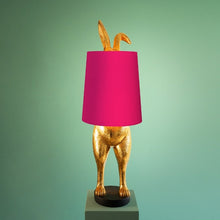 Lade das Bild in den Galerie-Viewer, Die Lampe Hiding Bunny von Werner Voss ist ein goldfarbener Hase, der sich hinter einem pinken Lampenschirm versteckt. Die Beine und Ohren des Osterhasen gucken hervor. Ideal als Stehlampe im Wohnzimmer oder Leuchte für Ostern und die Osterdeko.
