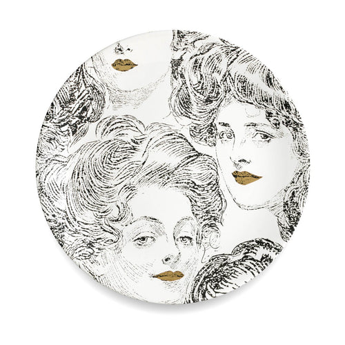 Wandteller aus weißem Porzellan mit einem Motiv von Frauenköpfen. Die Gesichter der Frauen sind in schwarz aufgedruckt, die Lippen der Damen sind gold-farben. Moderne Design-Wanddeko im Stil von Fornasetti.