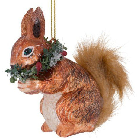 Weihnachtsanhänger in Form eines Eichhörnchens mit buschigem Schwanz und einer Tannengirlande um den Hals.