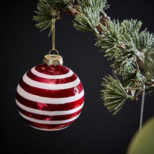 Lade das Bild in den Galerie-Viewer, Rote Weihnachtskugel aus Glas mit weißen Streifen, aufgehangen an einem Tannenzweig.
