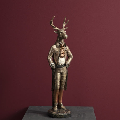 Deko Figur von Werner Voß in Form eines aufrecht stehenden Hirsch in Frack und mit Gehstock mit leichtem Goldschimmer überzogen.